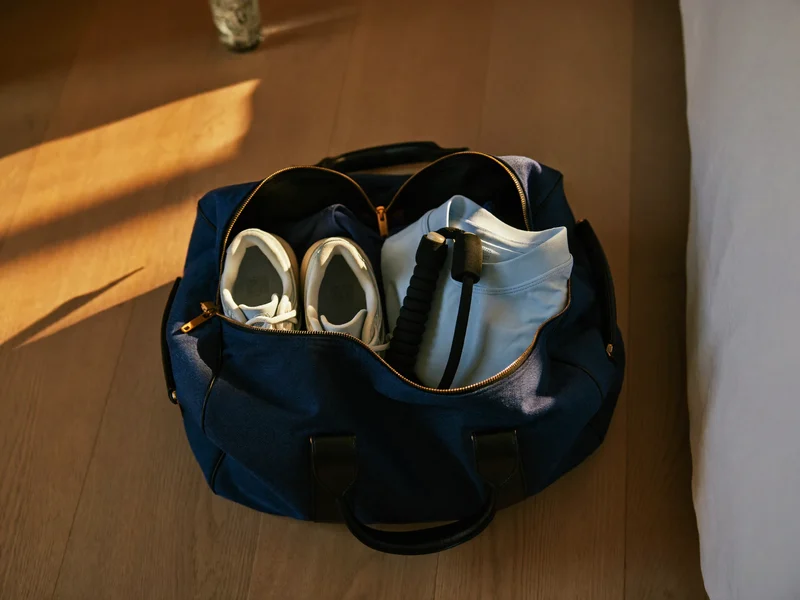 Gepackte Duffelbag von oben mit Laufschuhen, Shirt und Springseil